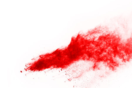 Freeze motion of red powder exploding, isolated on white background. Abstract design of red dust cloud. Particles explosion screen saver, wallpaperの写真素材