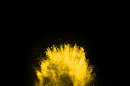 Freeze motion of yellow dust explosion isolated on black background.