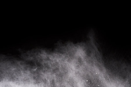 White powder explosion on black background. Colored cloud. Colorful dust explode. Paint Holi.の写真素材