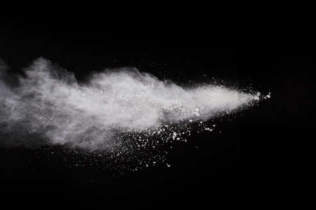 White powder explosion on black background. Colored cloud. Colorful dust explode. Paint Holi.の写真素材