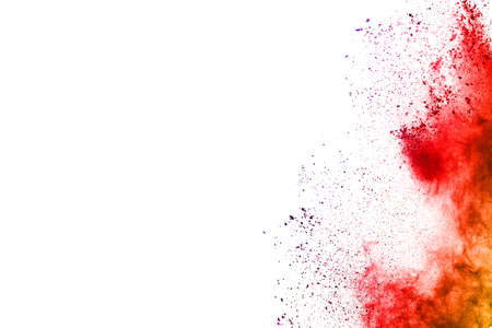 Freeze motion of red powder exploding, isolated on white background. Abstract design of red dust...