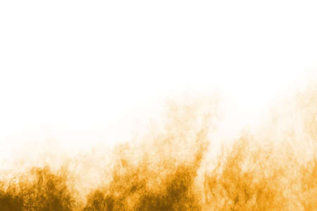 Powder explosion. Closeup of a yellow dust particle explosion isolated on white. Abstract backgroundの写真素材