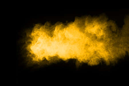 Freeze motion of yellow dust explosion isolated on black background.の写真素材