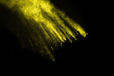 Freeze motion of yellow dust explosion isolated on black background.の写真素材