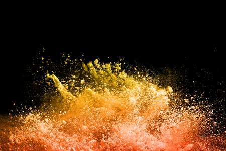 Freeze motion of yellow dust explosion isolated on black background.の写真素材