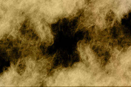 Golden powder explosion on black background. Freeze motion.