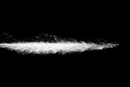 Freeze motion of white particles on black background. Powder explosion. Abstract dust overlay texture.の写真素材
