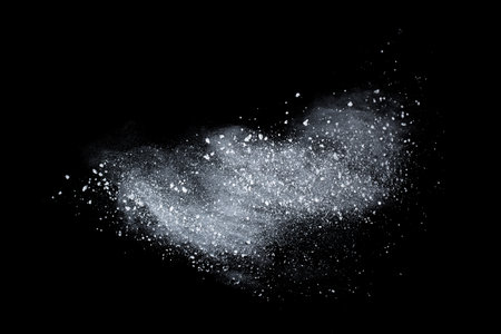 Freeze motion of white dust explosion isolated on black background. Abstract dust overlay texture.の写真素材