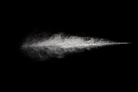 Freeze motion of white dust explosion isolated on black background. Abstract dust overlay texture.