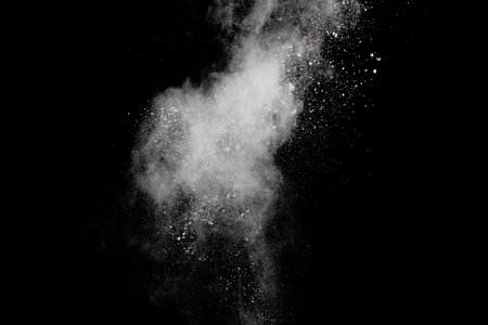 White powder explosion on black background. Abstract white dust cloud texture.の写真素材
