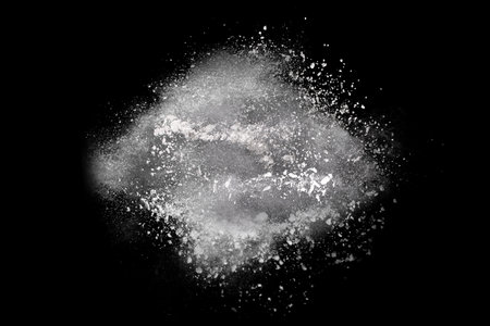 Freeze motion of white dust explosion isolated on black background. Abstract dust cloud texture.の写真素材