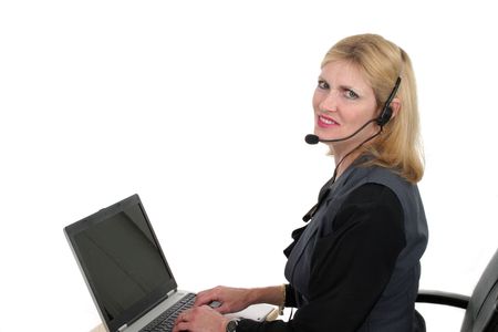 Attractive, smiling, customer service operator representative working at a computer with telephone headsetの写真素材