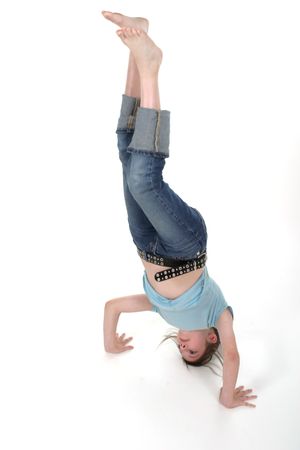 Young pre teen girl standing on her head or doing a handstand.
