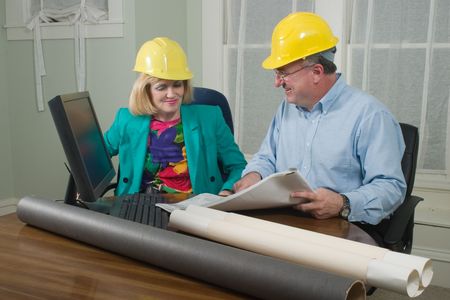 Architect showing client blueprints in the office.  Landscape horizontal orientation.の写真素材