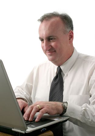 smiling business man typing and working on laptop computer; isolated on white backgroundの写真素材