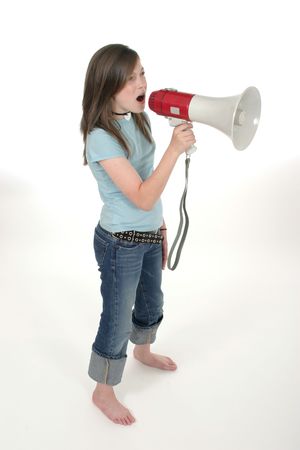 Young pre teen or tween girl shouting, speaking, or singing through a megaphone. Shot on whiteの写真素材