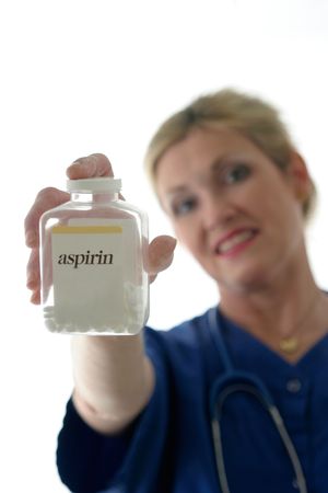 photo of nurse with stethoscope holding bottle of pills with aspirin on label in front of her; focus is on bottle of aspirin with nurse in background out of focusの写真素材