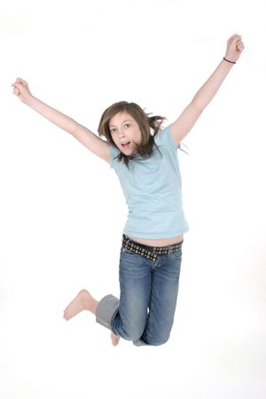 Young pre teen or tween girl jumping up in the air with arms outstretched.  Shot on white.の写真素材