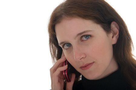 Close-up shot of young brunette woman in black shirt talking on cell phone with intense eyes toward the camera. Tight headshot.の写真素材