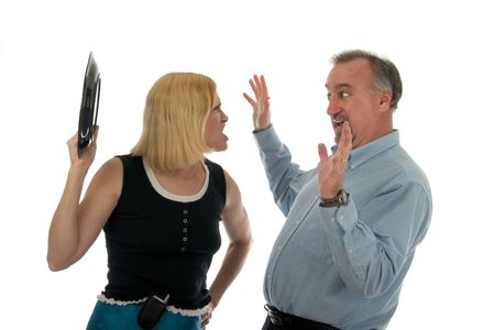 Wife shouting at, and about to hit, defensive husband with dinner plate in heated argument.の写真素材