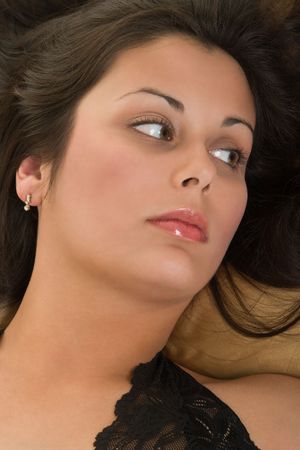 Beautiful Hispanic woman lying down peacefully on satin pillow, relaxing comfortably.の写真素材