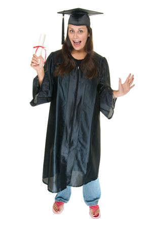 Very excited and happy beautiful young woman standing in graduation robes, cap and gown smiling and holding her diploma or degree. The graduate has moved the tassle from the left to the right side of the mortarboard.の写真素材