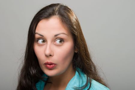 Beautiful young brunette woman with facial expression of surprise, excitement, embarassment, or amazement.の写真素材