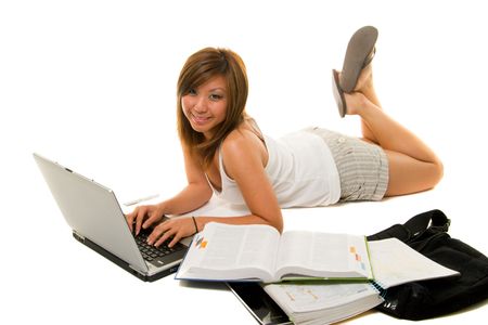 Young Asian girl sitting on the floor studying and working on laptop computer and books.の写真素材