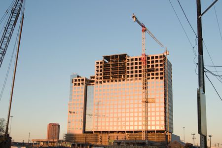 Building under construction using a crane with workers gone for the day.の写真素材