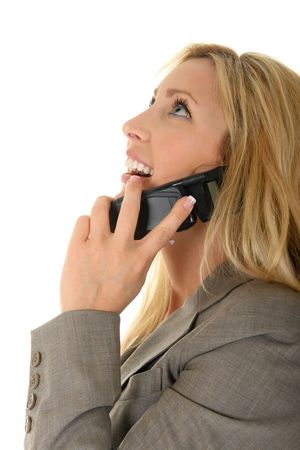 Beautiful blonde woman is talking on a cellphone, tossing her head back laughing and smiling.の写真素材