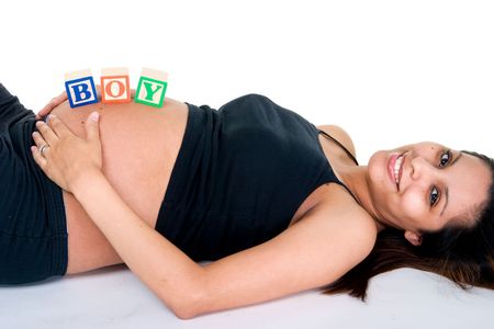 A young pregnant woman is lying down with  blocks on her stomach spelling の写真素材