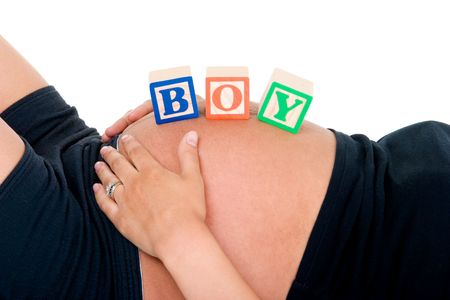 A young pregnant woman is lying down with  blocks on her stomach spelling の写真素材