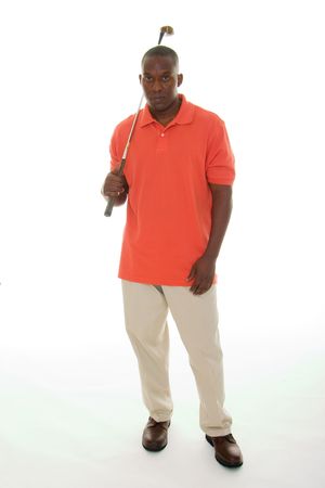 Casual young African American man in a bright orange golf shirt holding a golf club.の写真素材