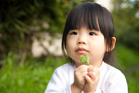 Young child holding a plant in her handの写真素材