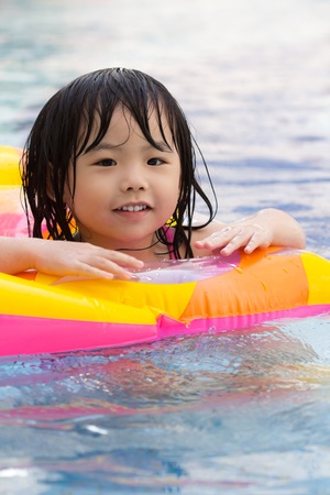 Little girl is having fun in swimming poolの写真素材