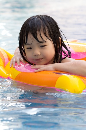 Little girl is having fun in swimming poolの写真素材