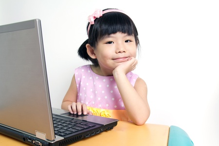 Little child girl is using laptop computer