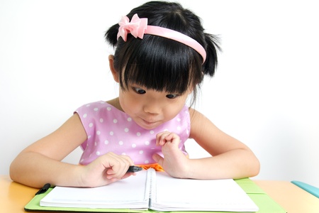 Little kid is looking at her book surprisinglyの写真素材