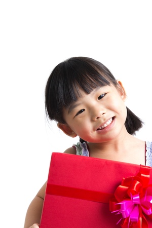 Portrait of Asian child girl with red gift box represents Christmas themeの写真素材