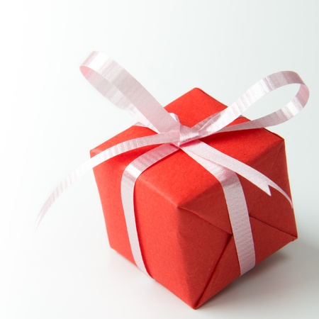 Red gift box with pink color ribbon isolated on white backgroundの写真素材