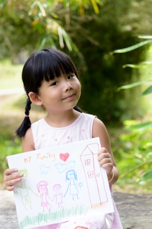 Little child shows drawing of her family memberの写真素材