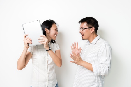 Asian couples fighting for a tablet pc