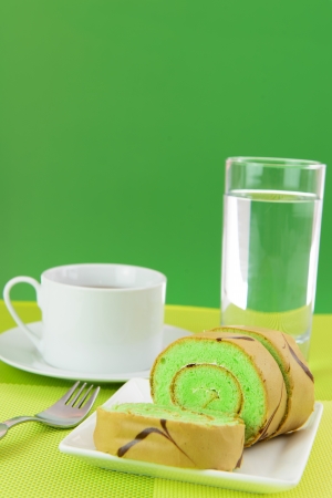 Slices of green Swiss roll served in plateの写真素材