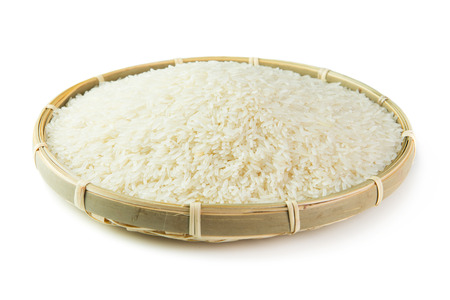 Rice grain on bamboo basket over white backgroundの写真素材