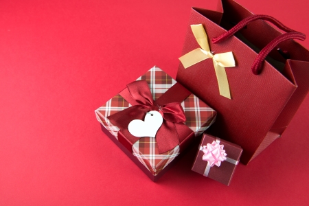 Red gift boxes and gift bag over red backgroundの写真素材