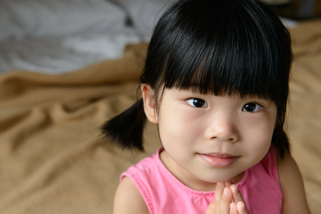 Portrait of little Asian child wearing pink indoorの写真素材