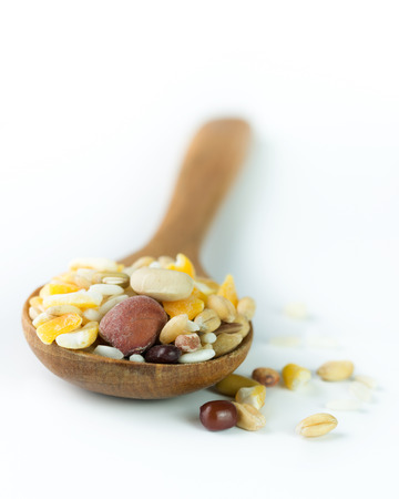 Mixed healthy grains on wooden spoon over white backgroundの写真素材