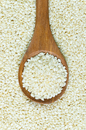 Heap of white sesame on wooden spoonの写真素材