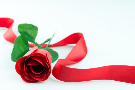 Red rose flower with red ribbon on white backgroundの写真素材