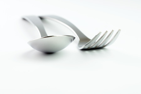 Stainless steel fork and spoon isolated on white backgroundの写真素材